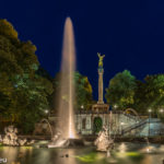 Der Friedensengel in München, Blick von unten mit dem Brunnen hoch zur Säule am späten Abend