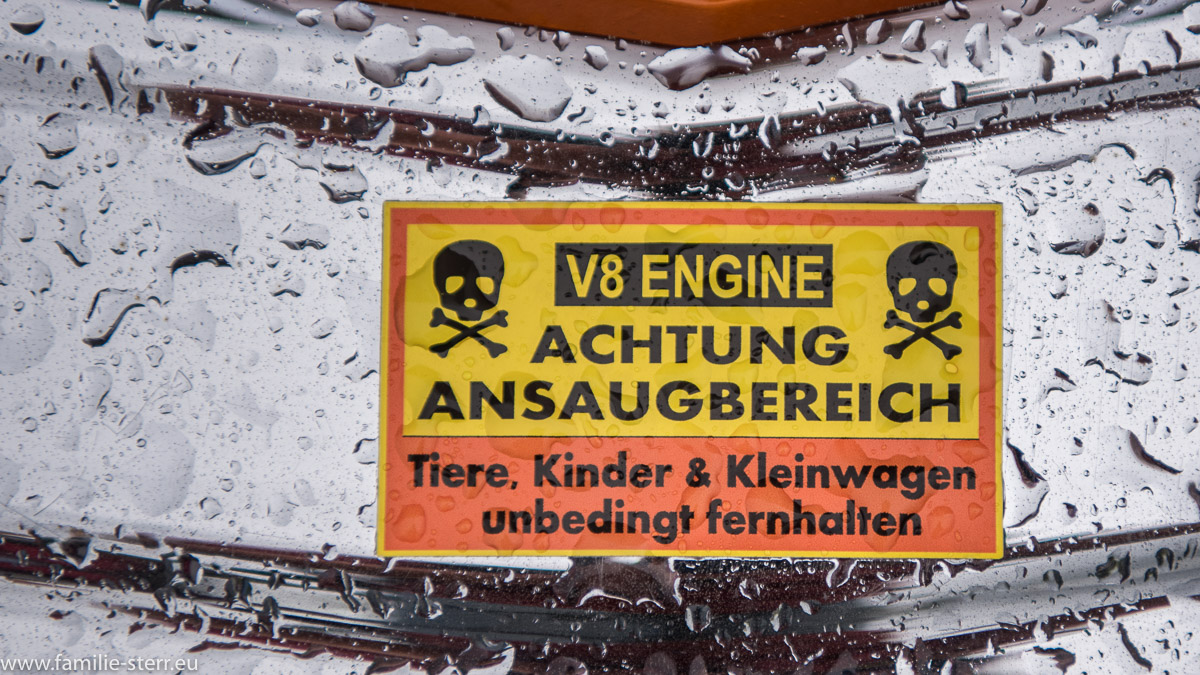 Warnhinweis "V8 Engine, Achtung Ansaugbereich, Tiere, Kinder und Kleinwagen unbedingt feenhaften"