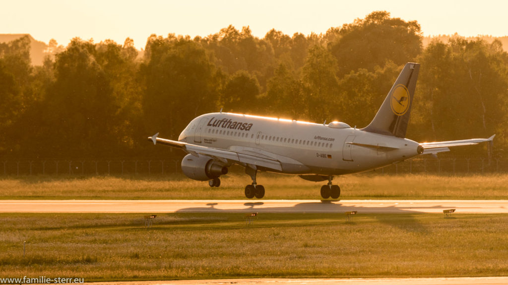 Ein Lufthansa - Airbus A319 landet in den Sonnenuntergang am Flughafen München