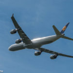 Abendsonne spiegelt sich im startenden Lufthansa Airbus A340-642 D-AIHX am Flughafen München