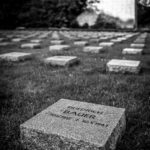 ein Name auf einem Gedenkstein in einer langen Reihe von Grabsteinen
