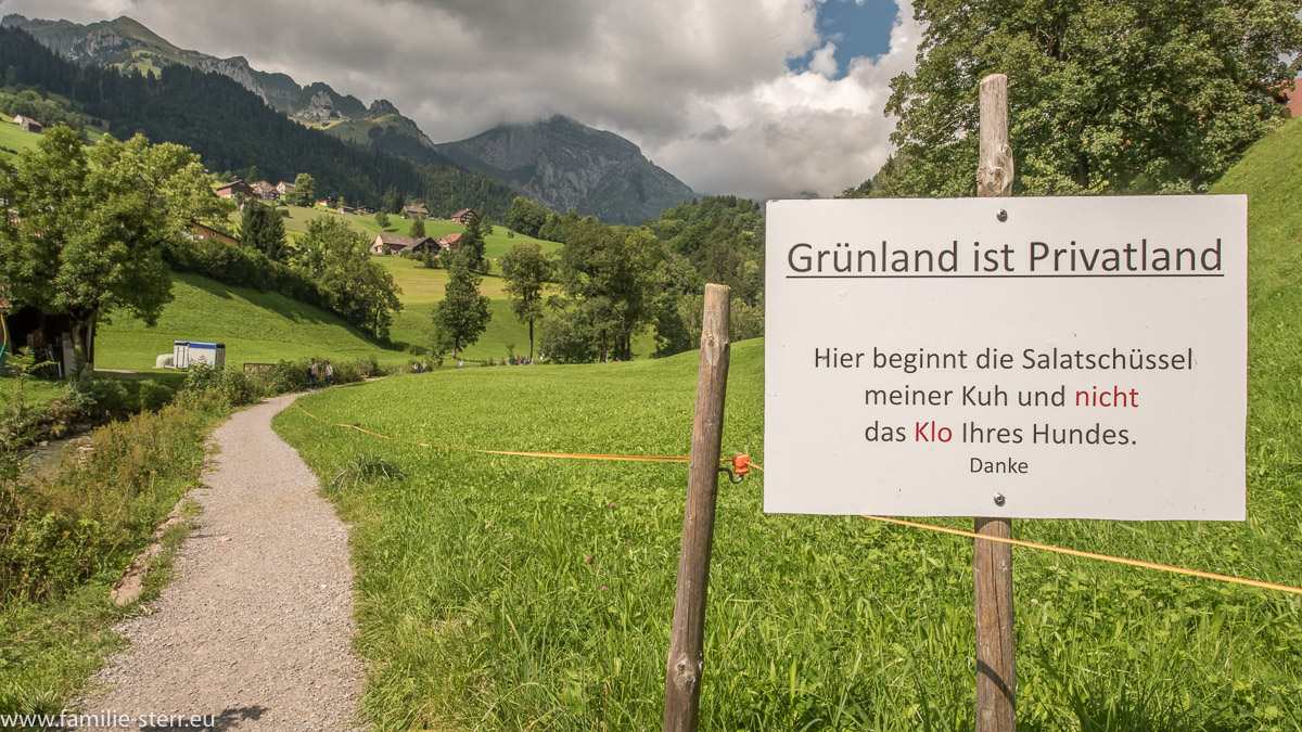 Hinweisschild mit dem Text "Grünland ist Privatland. Das ist die Salatschüssel meiner Kuh und nicht das Klo ihres Hundes" am Rande eines Wanderwegs im Kanton Sant Gallen