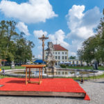 Altar und Kreuz vor dem Faunbrunnen im Barockpark am Schloss Fürstenried