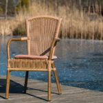 Stuhl im Sonnenschein am Rande des vereisten Bio - Badeteichs im Garten des Seehotel Burg im Spreewald