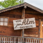 Schild "von Alm das Beste" am der Galopprennbahn in München Riem