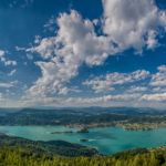 Panorama - Aufnahme vom Wörthersee in Kärnten bei strahlendem Sonnenschein und ein paar Wolken am blauen Himmel
