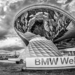 Blick auf die BMW - Welt von außen in schwarz - weiß an einem bewölkten Tag
