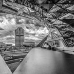 Blick von der BMW - Welt zum BMW - Vierzylinder an einem bewölkten Tag in schwarz - weiß