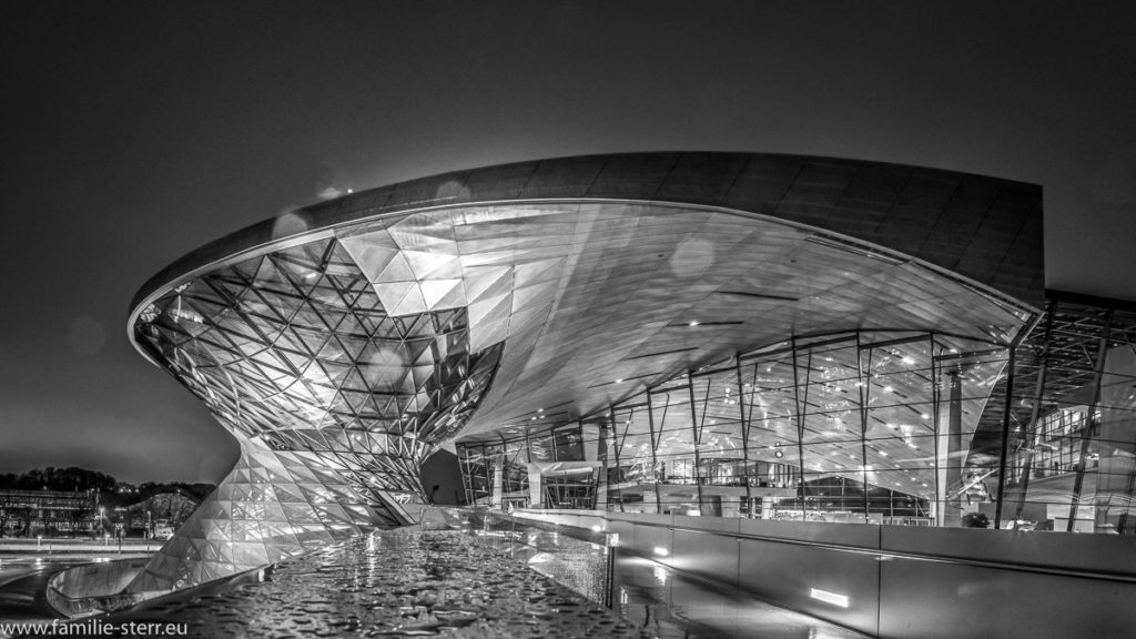 Blick auf die BMW - Welt von der Brücke zum BMW - Museum aus in einer regnerischen Nacht