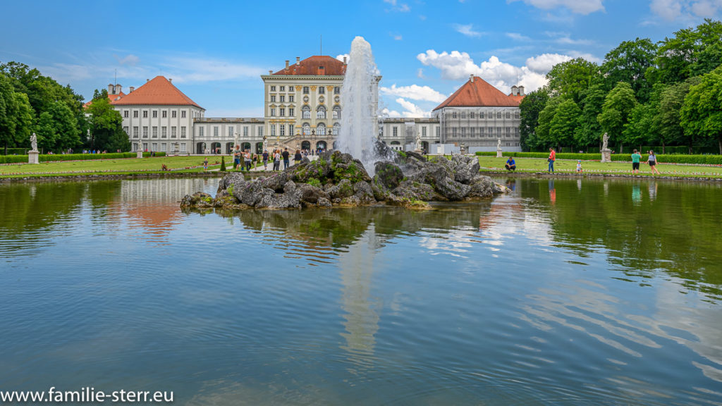 Brunnen vor dem Schloss Nymphenburg vor blau-weißem Himmel