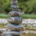 glitzerndes Wasser hinter einem Steinmännchen an der Isar bei Lenggries