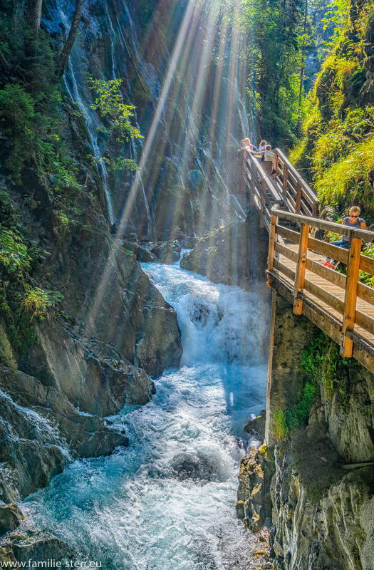 Sonnenstrahlen scheinen in die Klamm des Wimbach beim Ramsau und beleuchten den herbstlichen Wasserfall