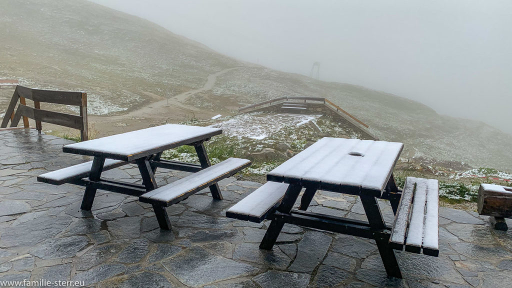 schneebedeckte Tische auf der Terrasse der Rudolfshütte beim Weißsee im Salzburger Land