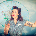 Burlesque - Workshop - junge Frau mit Sonnenschirm vor wolkigem Himmel