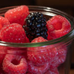 Himbeeren in einem Glas mit einer einzelnen Brombeere