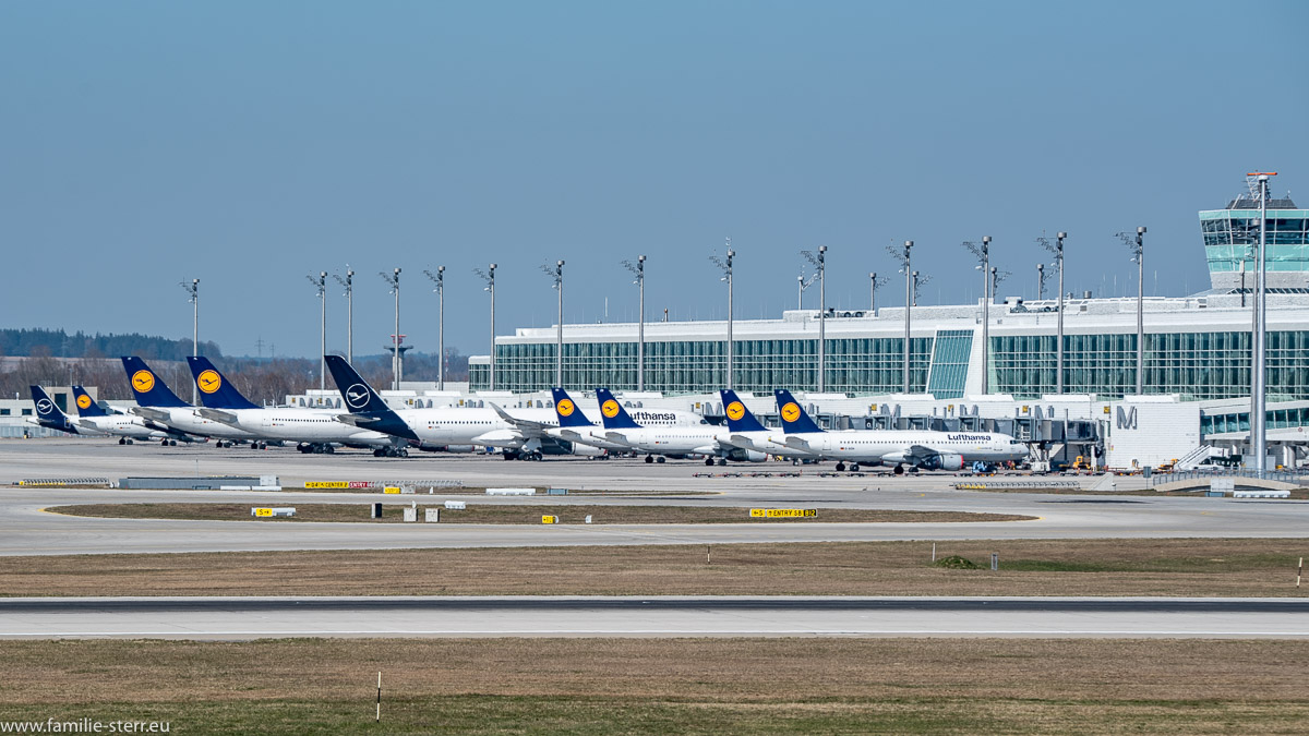 eine Reihe von Lufthansa - Flugzeuge parkt vor dem Satelliten am Terminal 2 am Flughafen München