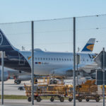 geparkte Flugzeuge der Lufthansa und leere Gepäckwagens auf dem Vorfeld West am Flughafen München