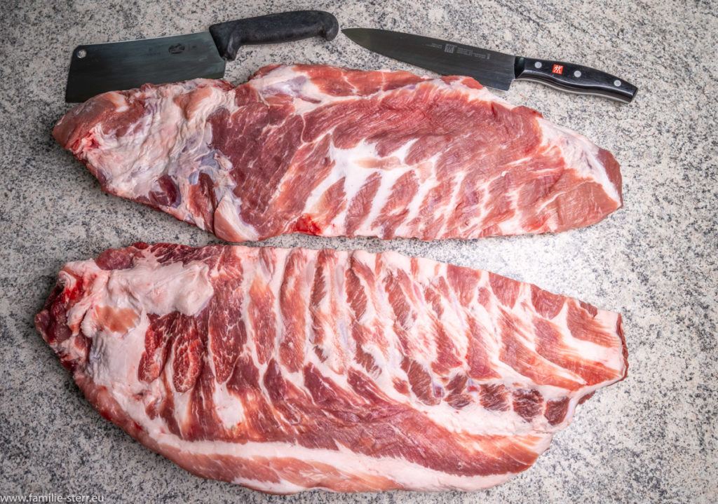 2 Reihen Spareribs mit viel Fleisch liegen Berit zur Zubereitung auf der Arbeitsplatte