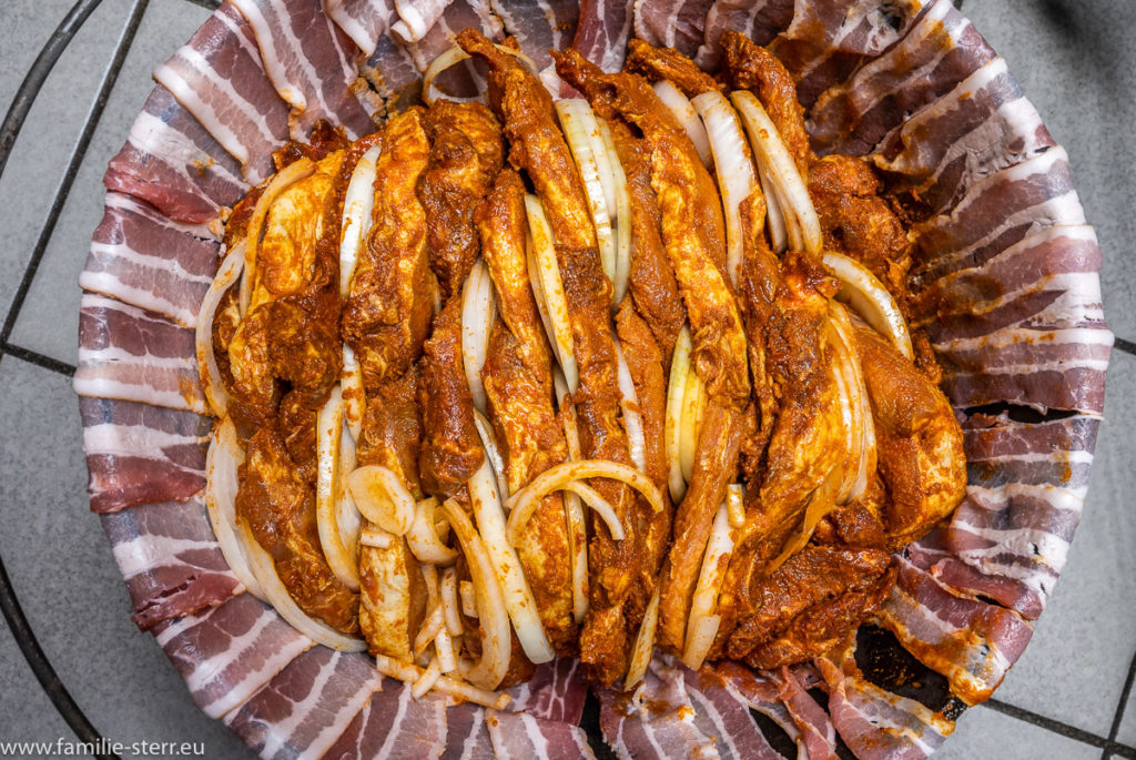 im Dutch - Oven geschichtetes Fleisch mit Zwiebeln auf einem Bacon - Bett