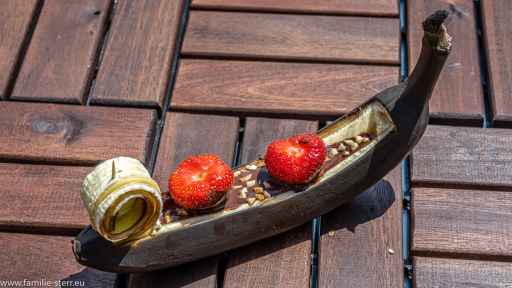eine gegrillte Schoko - Banane mit Erdbeeren und Haselnüssen in Form einer venezianischen Gondel
