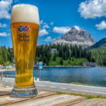 ein frisches Glas Weißbier vor dem Lago di Misurina und den Drei Zinnen in den Südtiroler Dolomiten