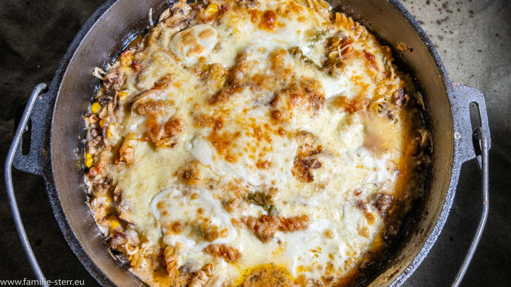 Blick von oben auf den mit Käse überbackenen Nudelauflauf in einem Dutch Oven