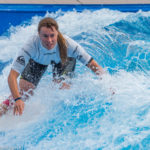 Surferin auf dem Board in der stehende Welle beim Surf and Style im Munich Airport Center