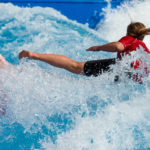 Surferin auf dem Board in der stehende Welle beim Surf and Style im Munich Airport Center