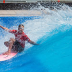 Surferin auf dem Board in der stehende Welle beim Surf and Style im Munich Airport Center