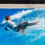 Surferin auf dem Board in der stehende Welle beim Surf and Style im Munich Airport Center