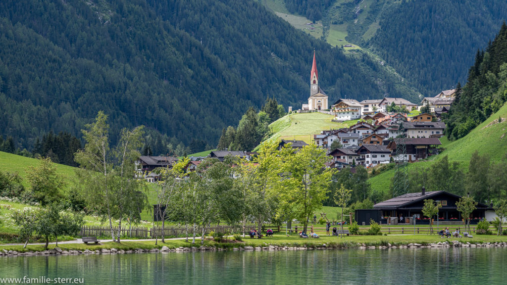 Blick über den Mühlwald - Stausee auf den Ort mit der auf einem Hügel thronenden Kirche