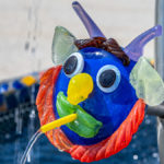 eine gläsernes Gesicht als Wasserspeier an einem Brunnen in der Josua Glaswelt