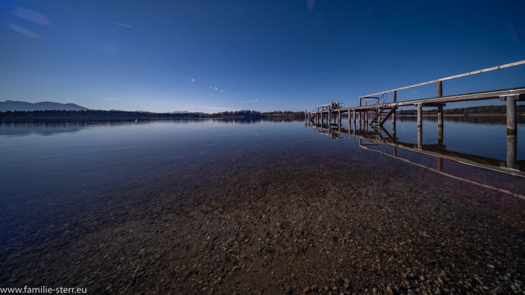 spiegelglattes Wasser vor dem Strandbad Breitbrunn mit dem Steg am rechten Bildrand