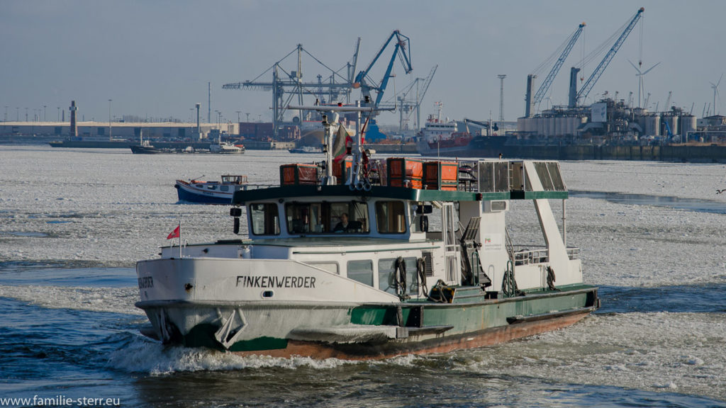 eine Hafenfähre fährt über die vereiste Elbe im Hafen bei St. Pauli