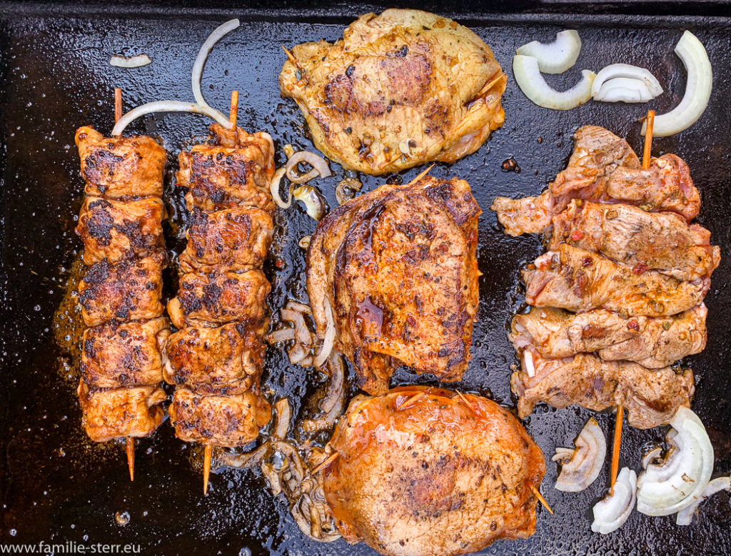 eine Platte voll Grillfleisch mit Zwiebeln