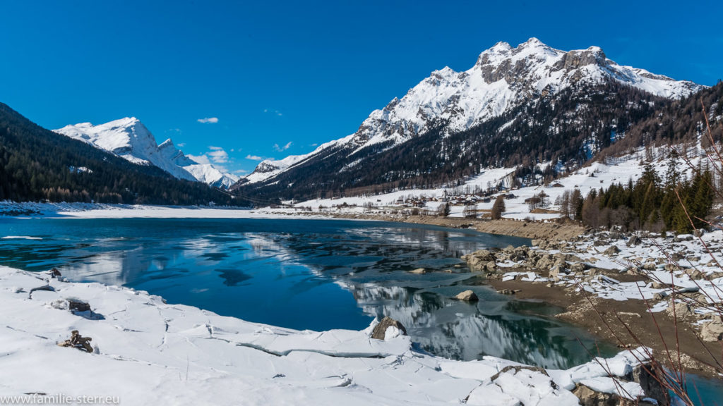 Bergsee vor verschneiten Alpengipfeln