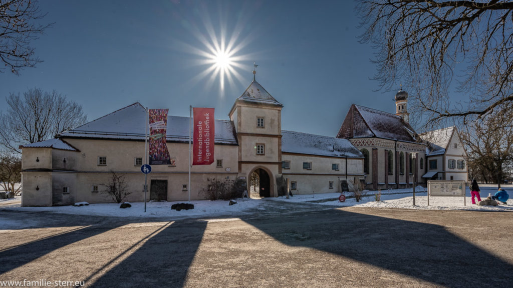 strahlende Sonne über dem Eingang zur Blutenburg an einem eiskalten WIntertag in München West