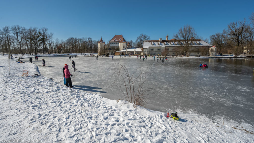 Schlittschufahrer auf dem gefrorenen Schlossteich vor der Blutenburg