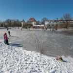 Schlittschufahrer auf dem gefrorenen Schlossteich vor der Blutenburg