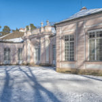 das Jagdschloss Amalienburg im winterlichen Schlosspark unter strahlend blauem Himmel