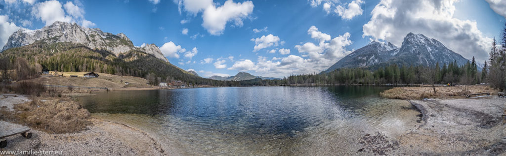 Panorama des Hintersees mit den umgebenden Bergen der Berchtesgadener Alpen unter weiß-blauem Himmel