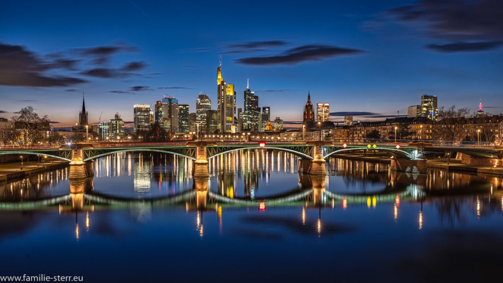 nächtlicher Blick über den Main auf das Bankenviertel mit den Hochhäusern in Frankfurt am Main zur blauen Stunde