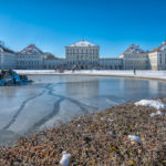 Fontäne und Ehrenhof vor dem Schloss Nymphenburg an einem strahlend blauen Wintertag