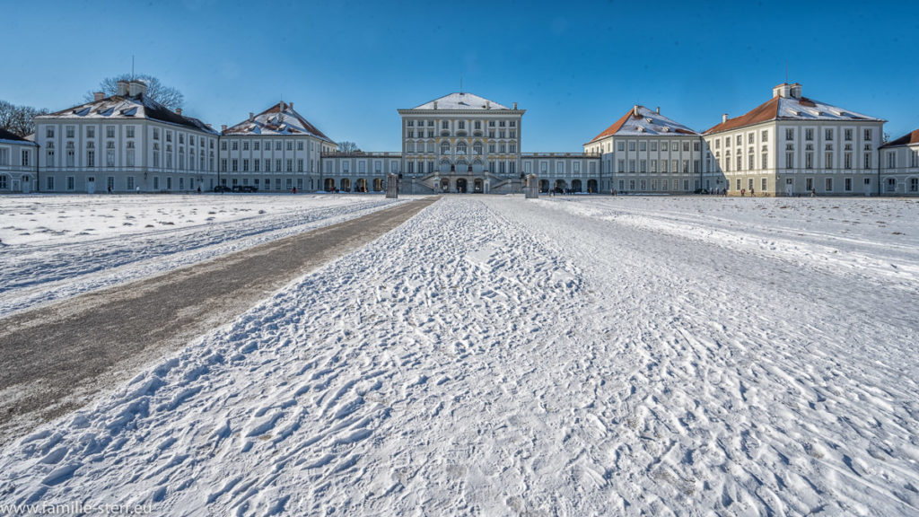 strahlend blauer Himmel über dem schneebedeckten Ehrenhof vor dem Schloss Nymphenburg