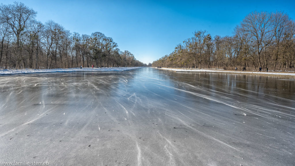 zugefrorener Kanal im Schlosspark Nymphenburg an einem strahlenden, aber eiskalten Wintertag