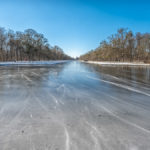 zugefrorener Kanal im Schlosspark Nymphenburg an einem strahlenden, aber eiskalten Wintertag