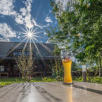 ein frisches Erdinger Weißbier im strahlenden Sonnenschein vor dem Wellnesshaus Arche Noah im Seehotel Burg Spreewald