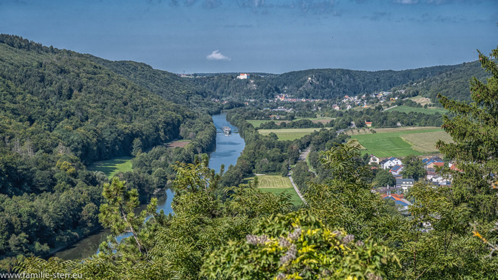 Blick von der Burg Prunn über den Main-Donau-Kanal, im Hintergrund liegt Riedenburg mit dem Schluss Rosenburg, auf dem Kanal fährt ein großer Ausflugsdampfer