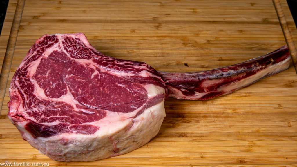 rohes Tomahawk - Steak auf einem Holzbrett