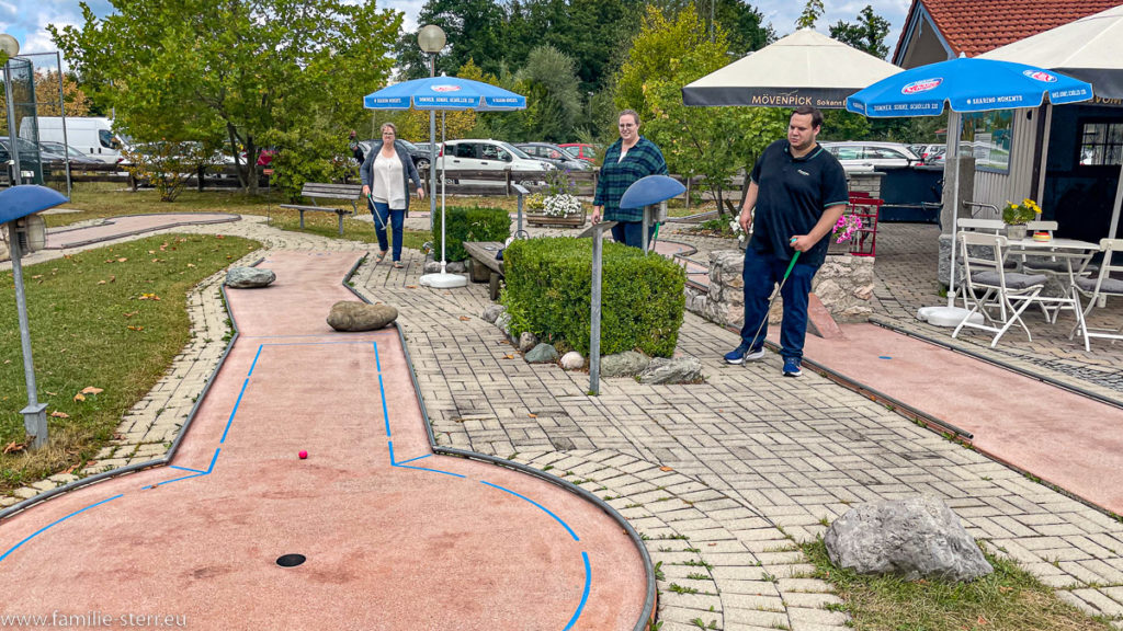 Katharina und Daniel bestaunen einen Schlag von Astrid auf der Bahn beim Minigolf in Prien
